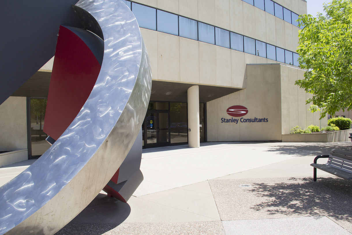 Exterior view of Stanley Consultants' headquarters in Muscatine, Iowa, featuring an abstract sculpture near the entrance.